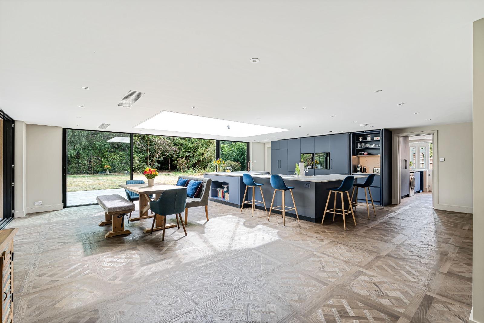 Wide view of Versailles-style LVT across an open-plan kitchen and dining room in Dorking