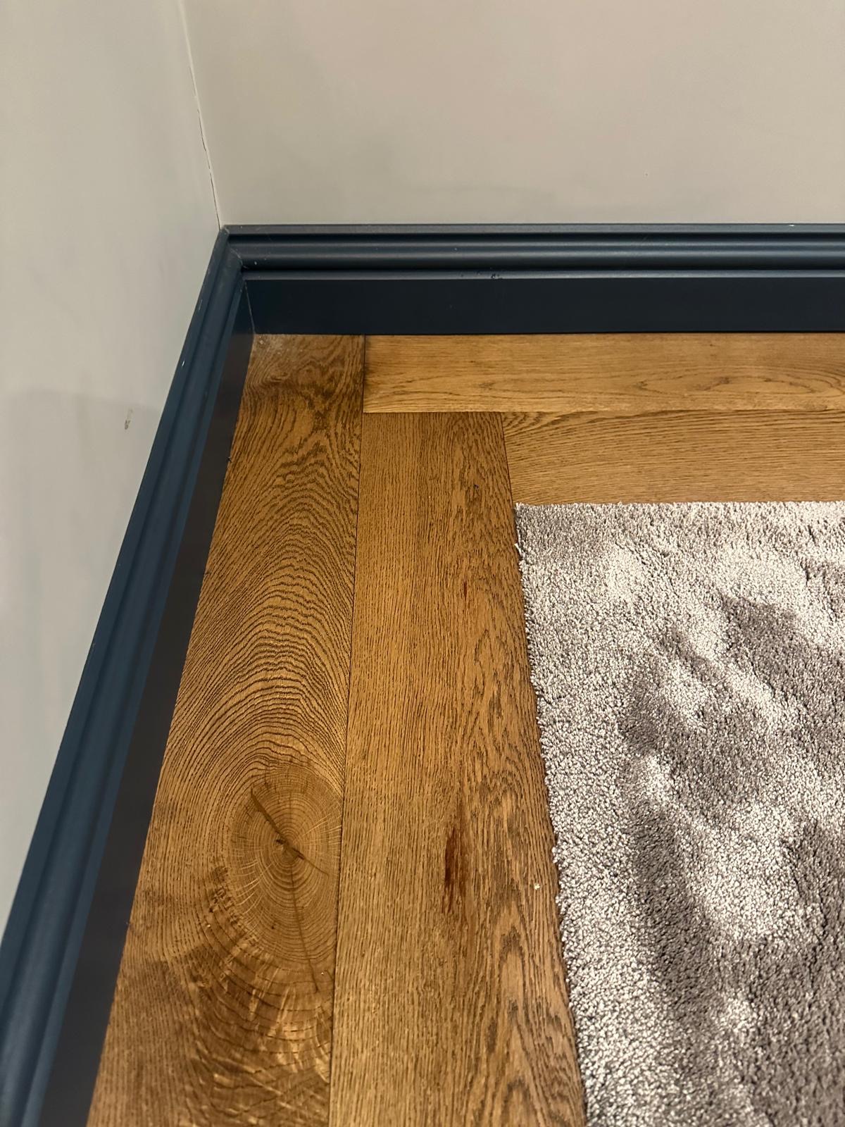 Close view of the fitted wood border meeting the soft carpet in the home cinema