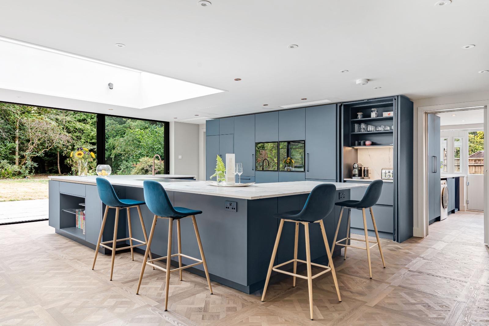 Versailles-style luxury vinyl flooring fitted around a large blue kitchen island in Dorking