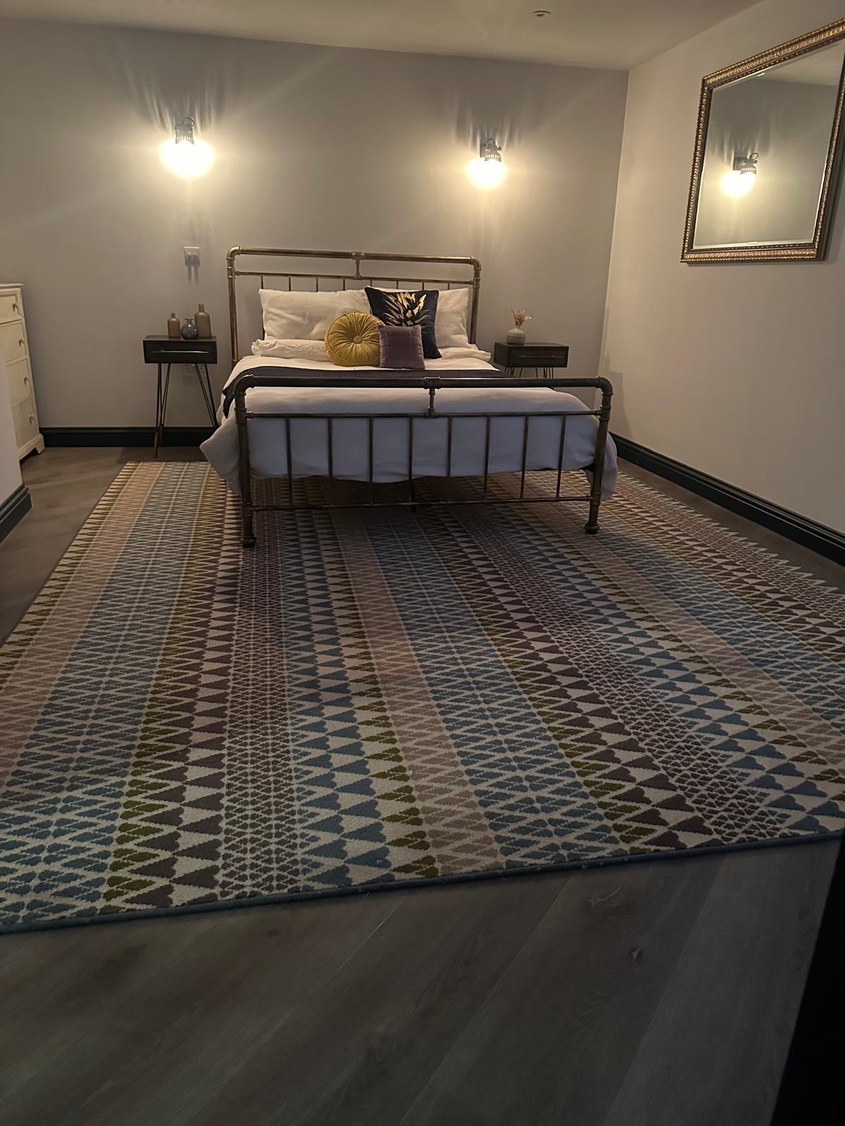 Patterned bedroom rug over fitted LVT flooring in a Godalming home