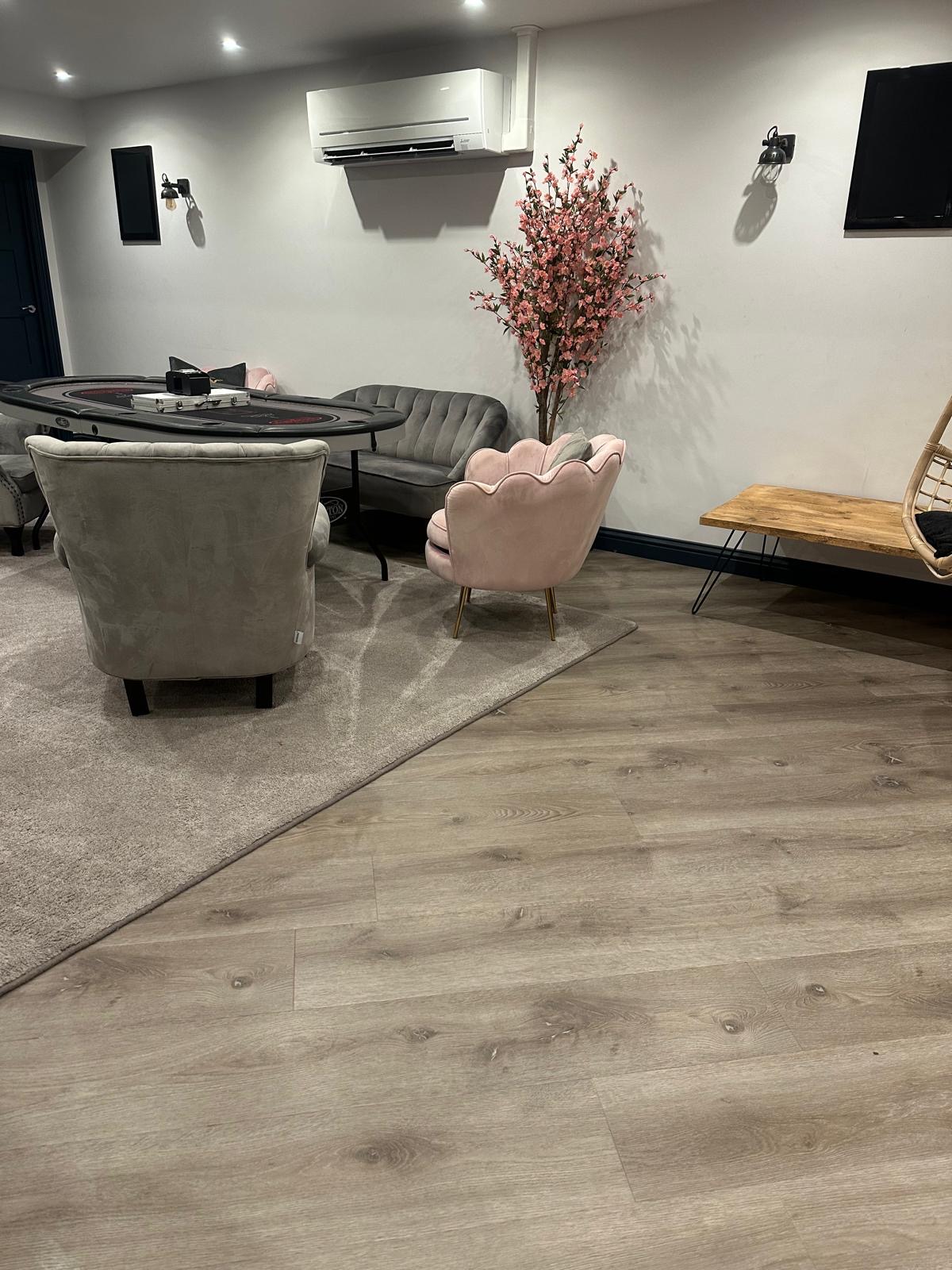 Bespoke edge-whipped carpet rug over LVT in the basement seating area