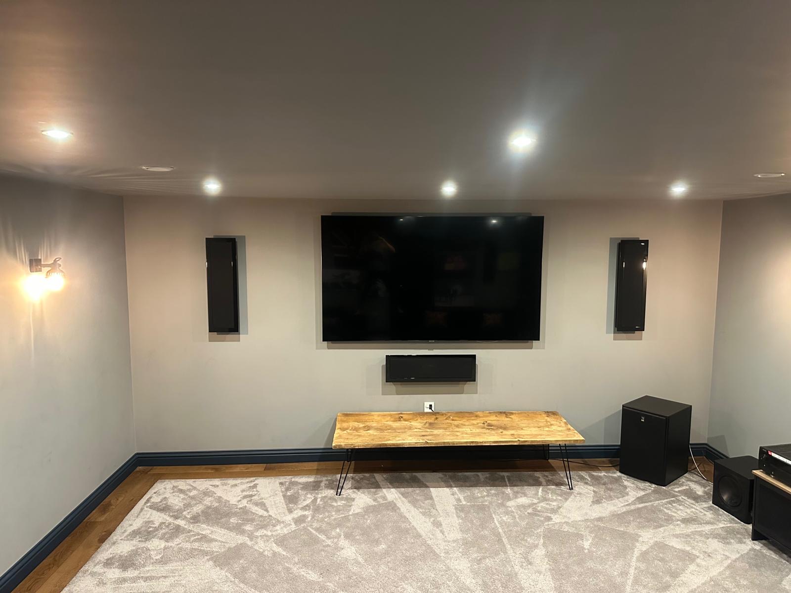 Carpet and wood flooring fitted around the screen wall in a Haslemere home cinema